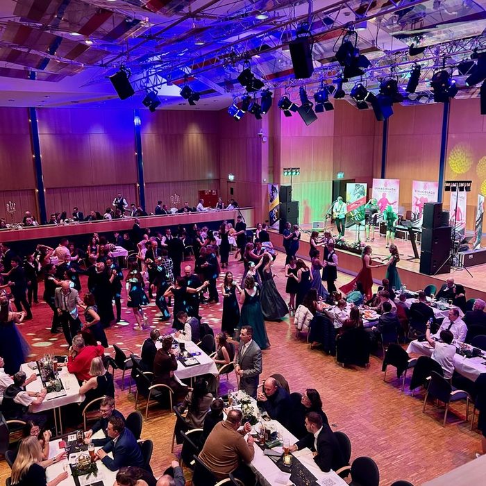 Voller Ballsaal mit Tanzfläche und Pina Colada auf der Bühne